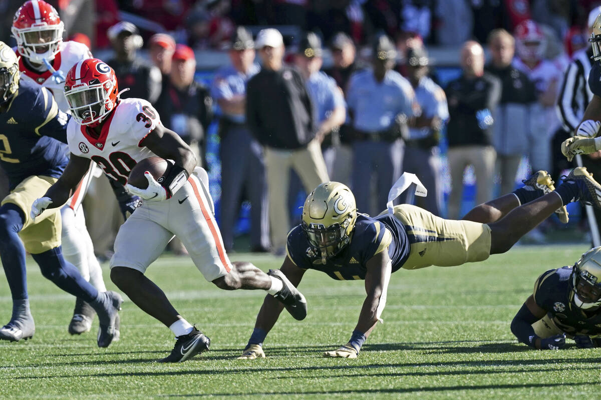 Georgia running back Zamir White (3) breaks away from Georgia Tech linebacker Quez Jackson (4) ...