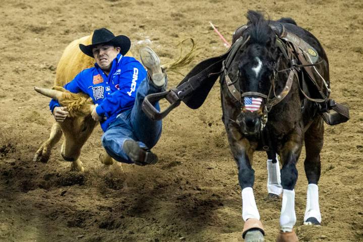 Dirk Tavenner of Rigby, ID., leaves his horse in Steer Wrestling to tie for first place during ...