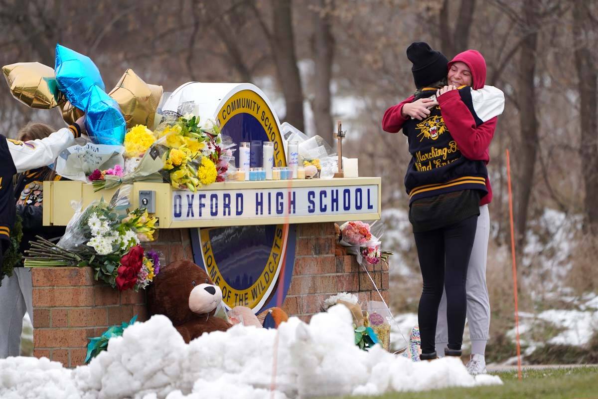 Students hug at a memorial at Oxford High School in Oxford, Mich., Wednesday, Dec. 1, 2021. Aut ...