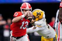 Georgia quarterback Stetson Bennett (13) gets past Missouri defensive lineman Isaiah McGuire (9 ...