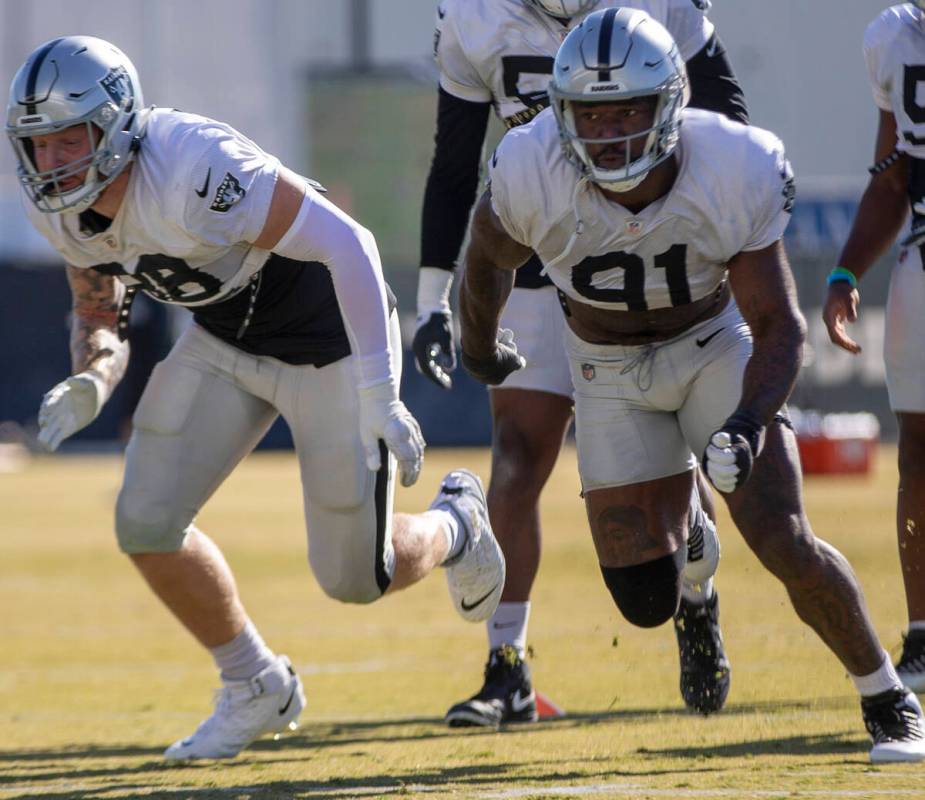 Raiders defensive end Maxx Crosby (98) and Raiders defensive end Yannick Ngakoue (91) sprint du ...