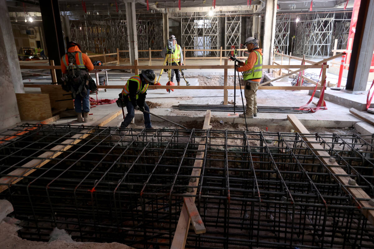 Workers prepare a column as construction continues on Project63, a four-story retail complex at ...