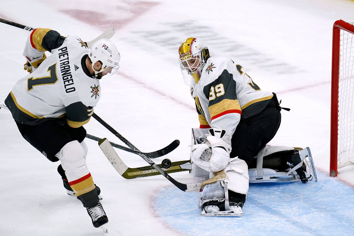 Vegas Golden Knights goalie Laurent Brossoit (39) gets help with defending against a shot by th ...