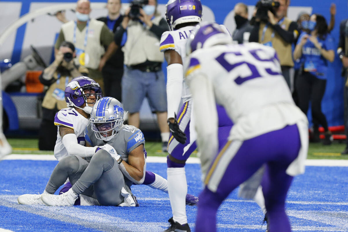 Detroit Lions wide receiver Amon-Ra St. Brown (14), defended by Minnesota Vikings cornerback Ca ...