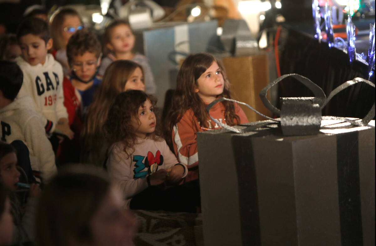 Children watch local performers Rinat Hahmigery and Gal Hayon performing before a candle lighti ...