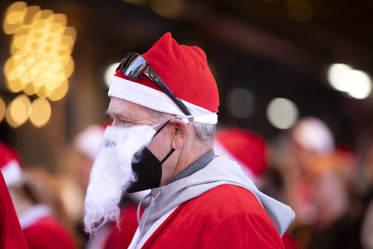 Jeff May wears a mask to prevent the spread of COVID-19 under his Santa beard during The Las Ve ...