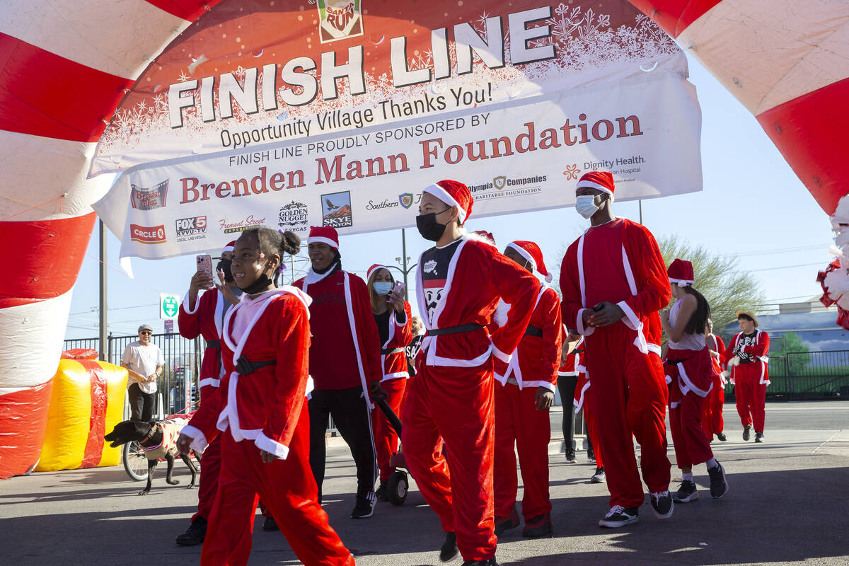 Runners reach the finish line during The Las Vegas Great Santa Run on Saturday, Dec. 4, 2021, i ...