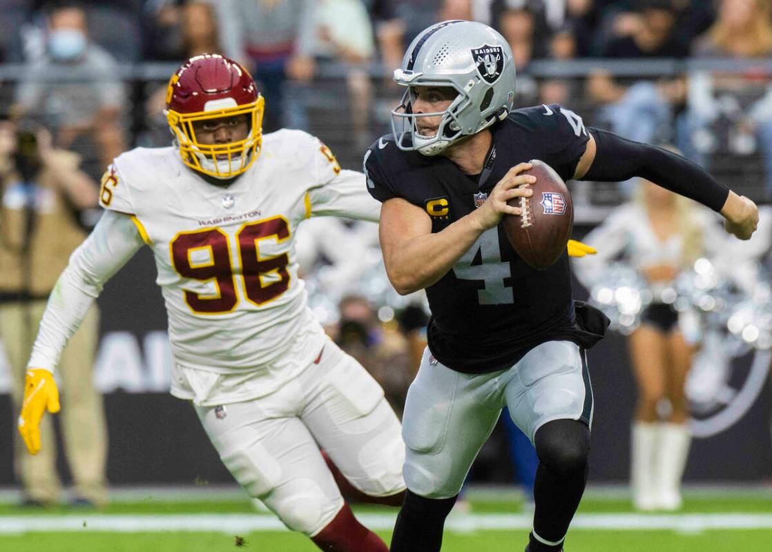 Raiders quarterback Derek Carr (4) scrambles away from Washington Football Team defensive end J ...