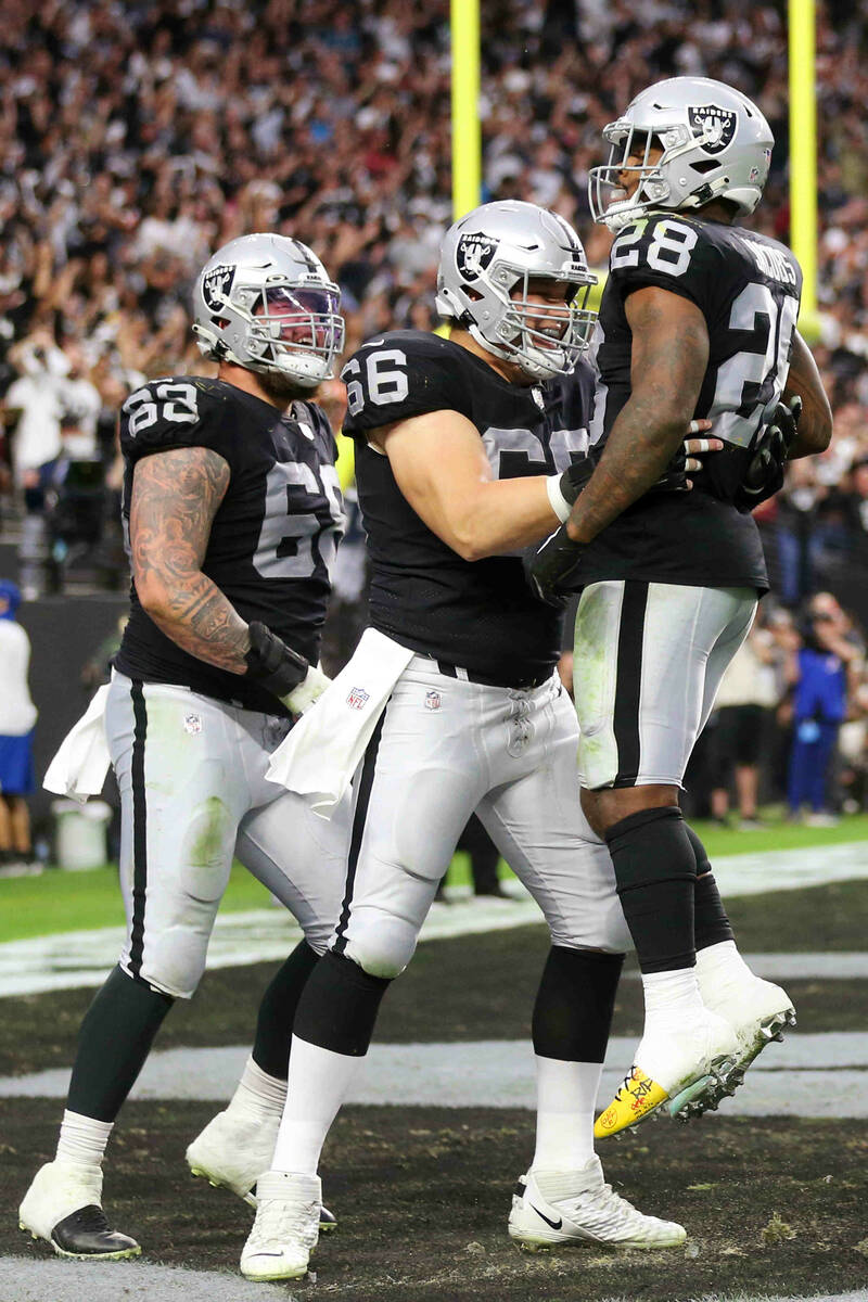 Raiders running back Josh Jacobs (28) celebrates a touchdown with center Nick Martin (66) and c ...