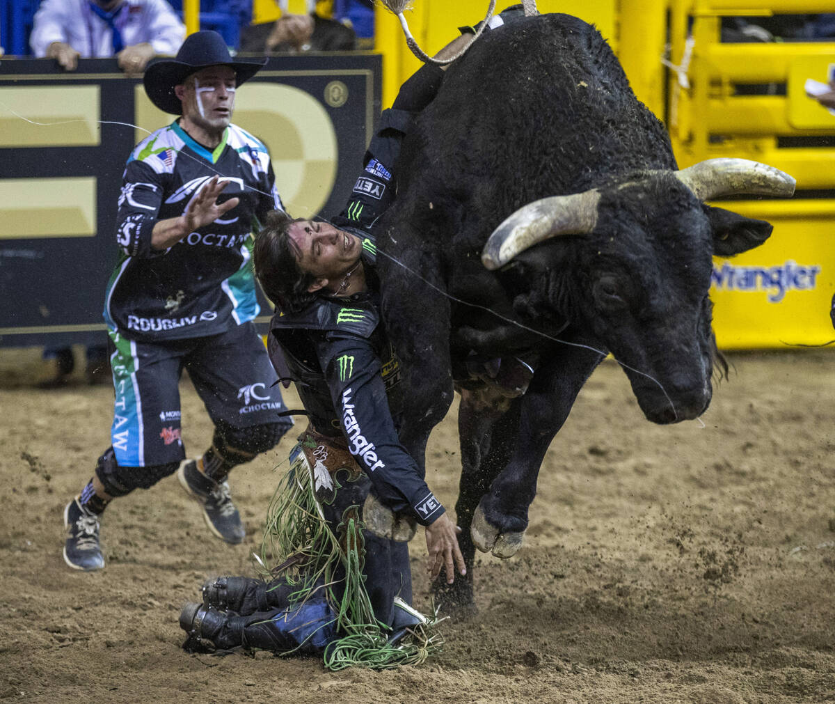 J.B. Mauney of Cotulla, TX., is dragged by Johnny Thunder in Bull riding as a bullfighter moves ...