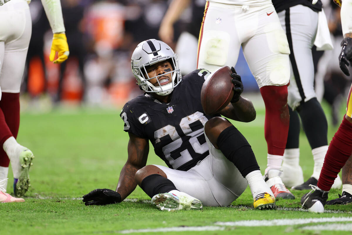 Raiders running back Josh Jacobs (28) gets up after falling during a run against the Washington ...