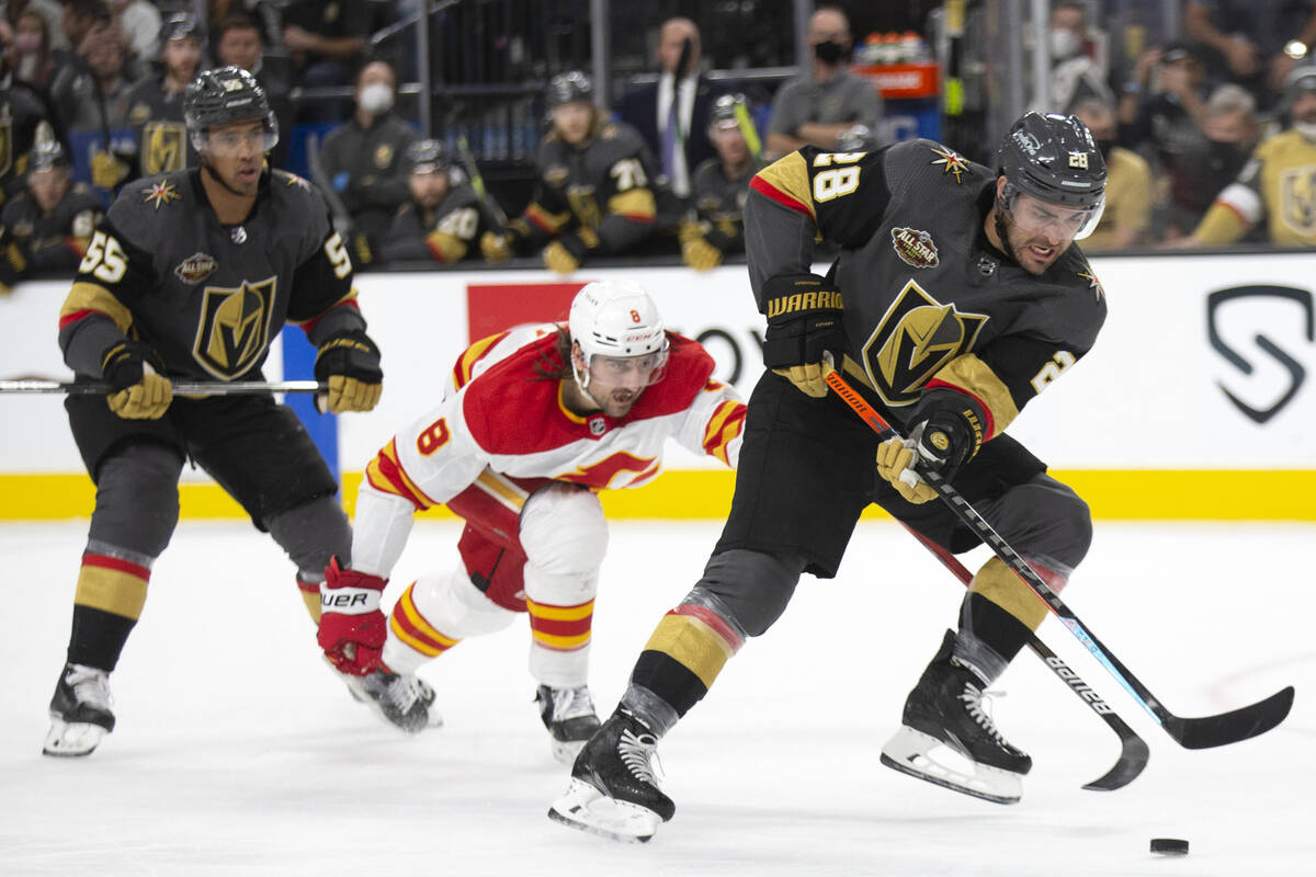 Vegas Golden Knights left wing William Carrier (28) skates with the puck while followed by Calg ...
