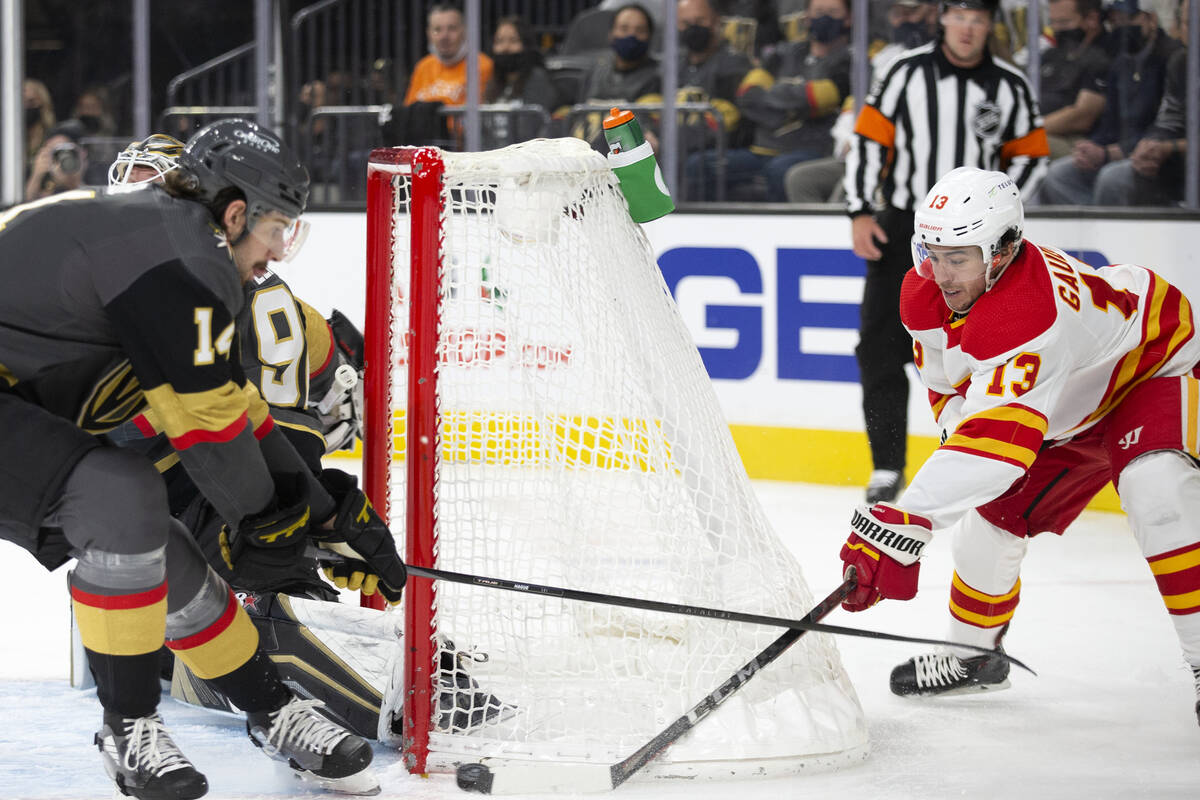 Calgary Flames left wing Johnny Gaudreau (13) takes a shot on goal while Vegas Golden Knights d ...