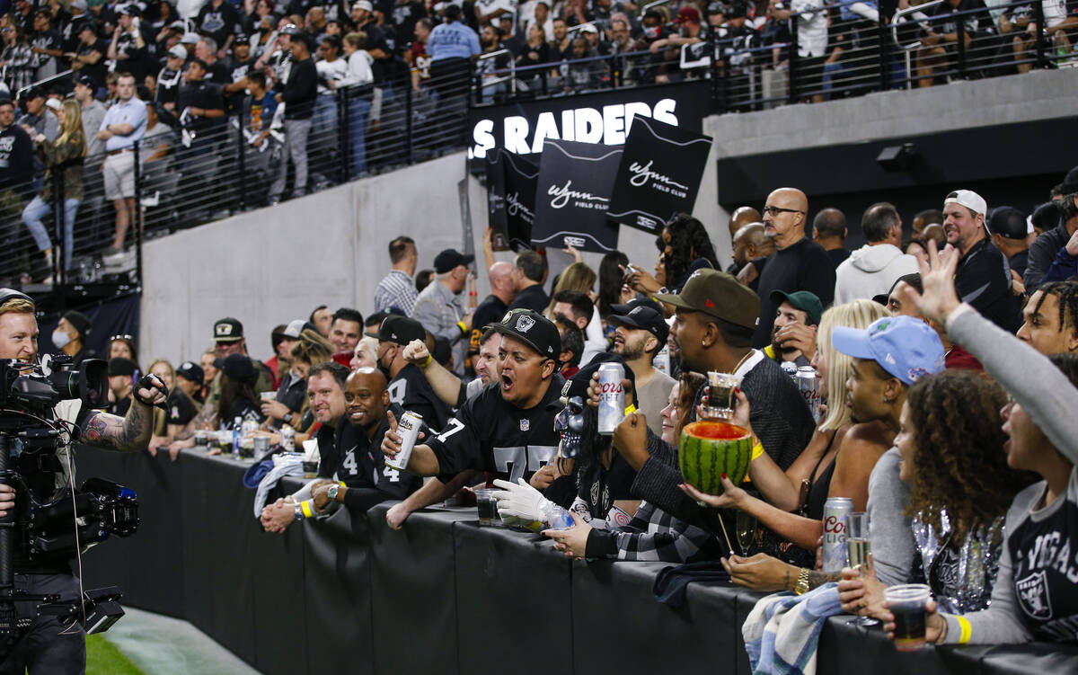 Football fans cheer for the camera at the Wynn Field Club during an NFL game between the Raider ...
