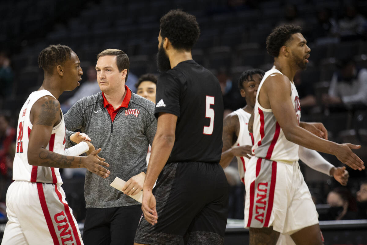 UNLV Rebels head coach Kevin Kruger slaps hands with guard Josh Baker (22) as the team heads to ...