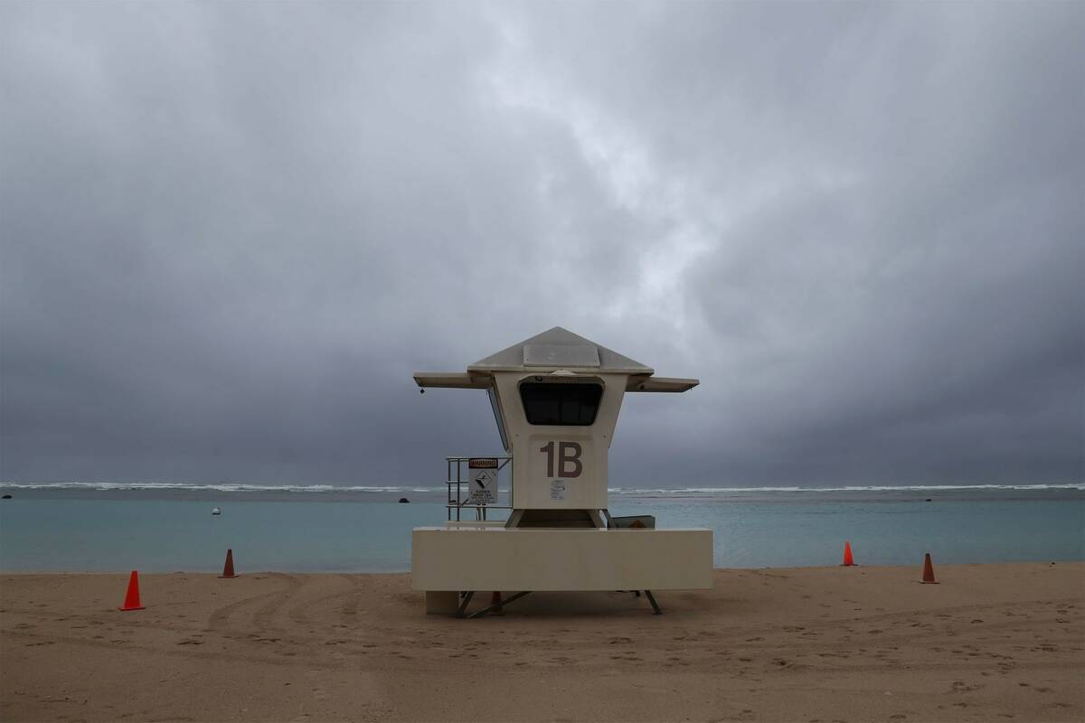 Dark clouds hang over a lifeguard tower on Ala Moana Beach Park, Monday, Dec. 6, 2021, in Honol ...