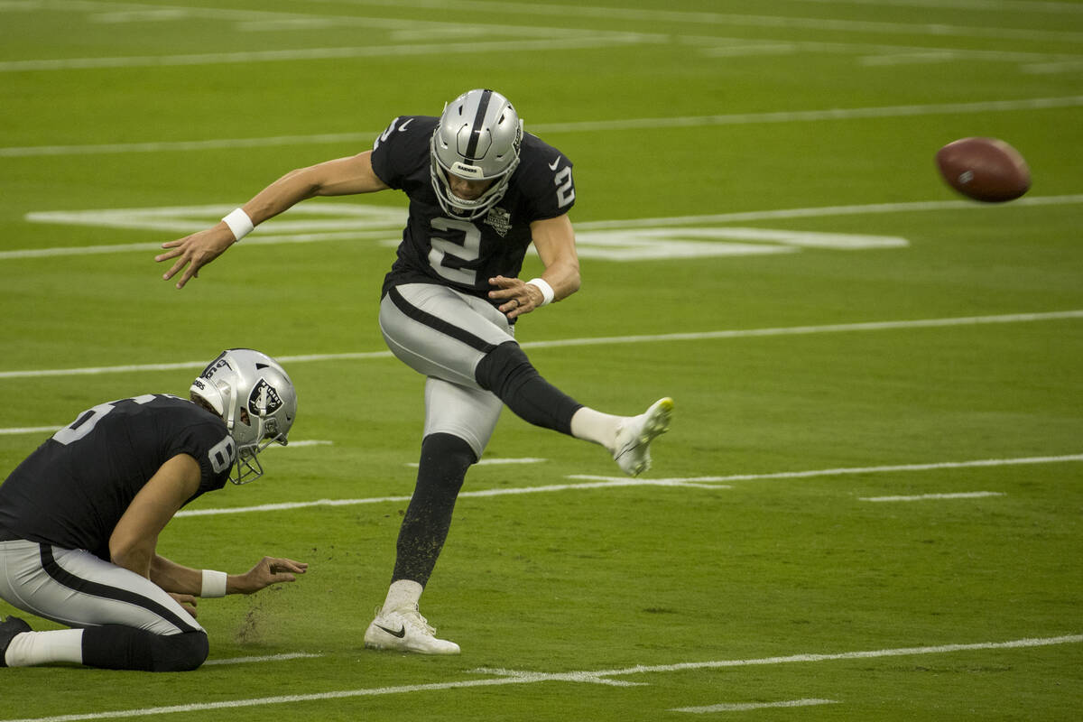 Las Vegas Raiders punter AJ Cole (6, left) holds the ball as place kicker Daniel Carlson (2) ge ...