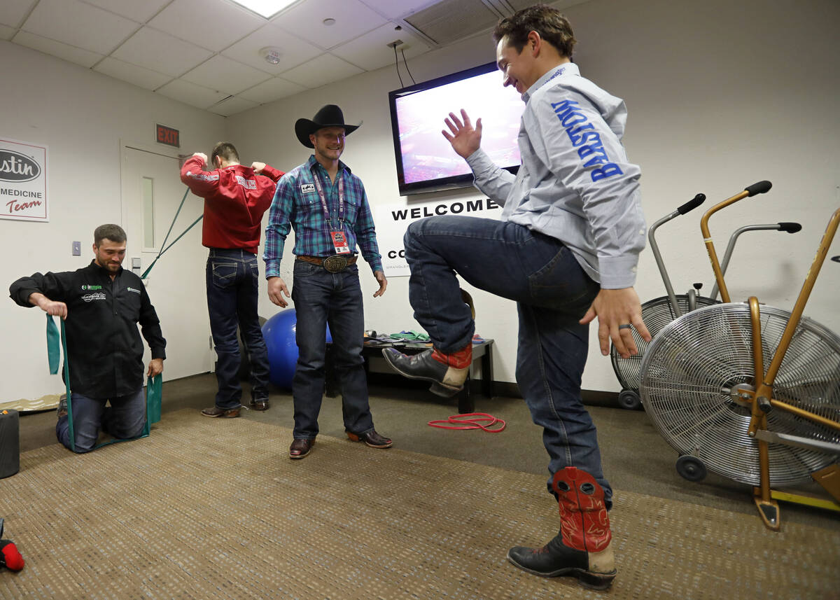 Former rodeo competitor Doug Champion, left, does physical therapy for competitor Clayton Biglo ...