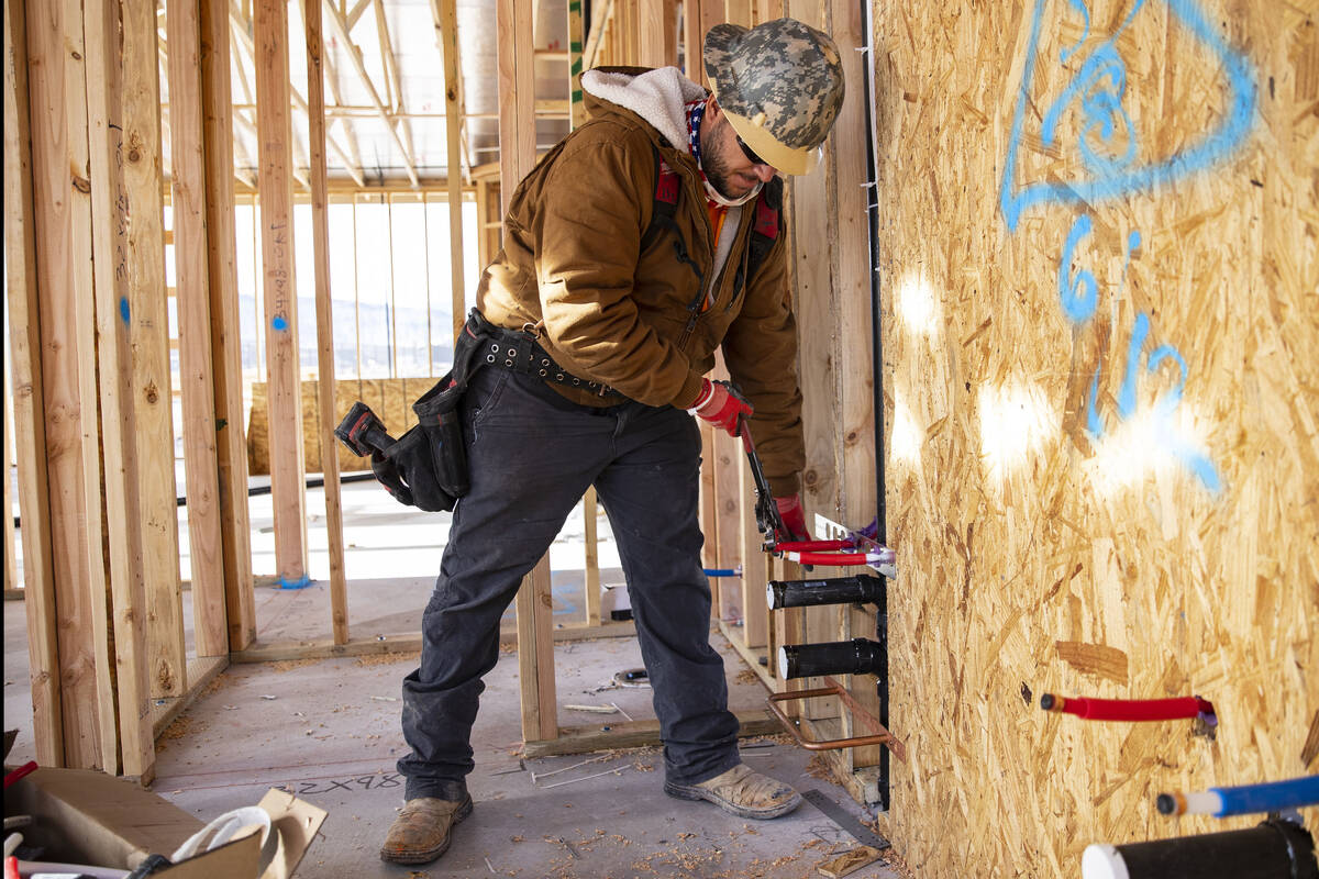 Miguel Ryes, a plumber for B2C Mechanical, works on water supply pipes at Lennar at Heritage at ...