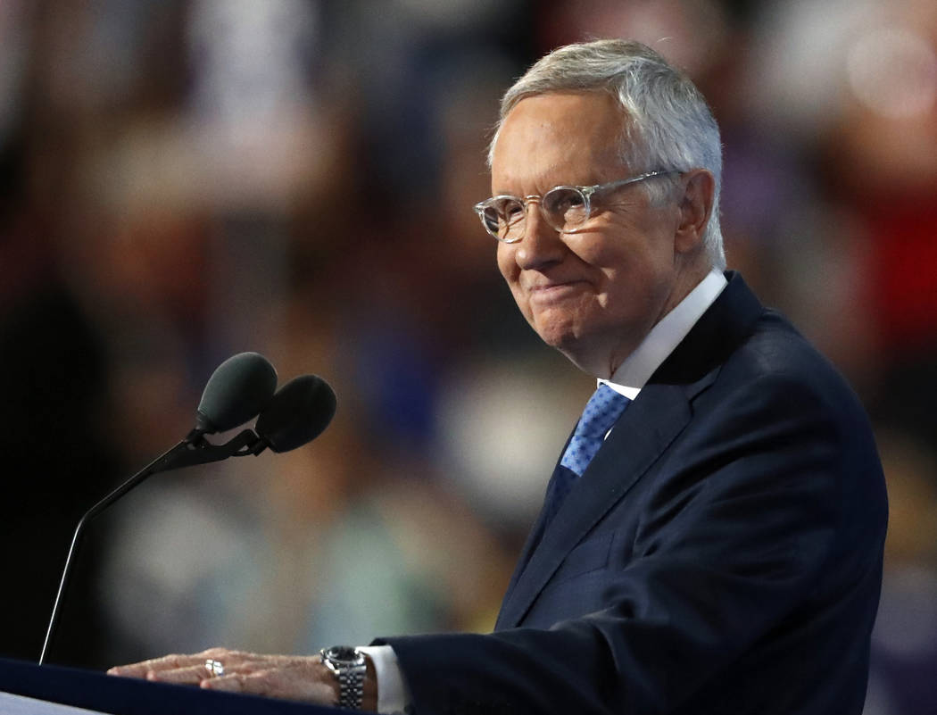 Senate Minority Leader Harry Reid of Nevada smiles from the podium as he speaks during the thir ...