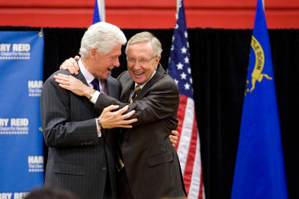 Former President Bill Clinton, left, shares a laughter  and a hug with U.S. Sen. Harry Reid, D-Nev. ...