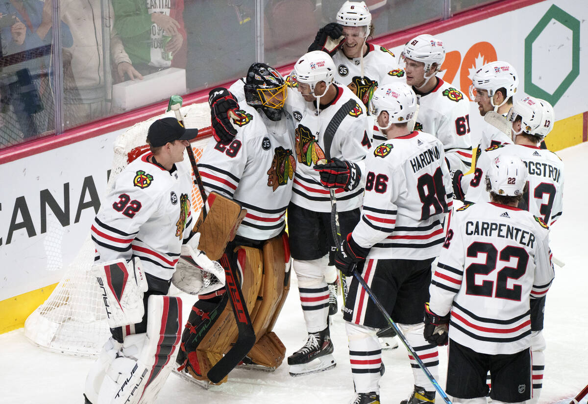 Teammates gather around Chicago Blackhawks goaltender Marc-Andre Fleury after recording his 500 ...