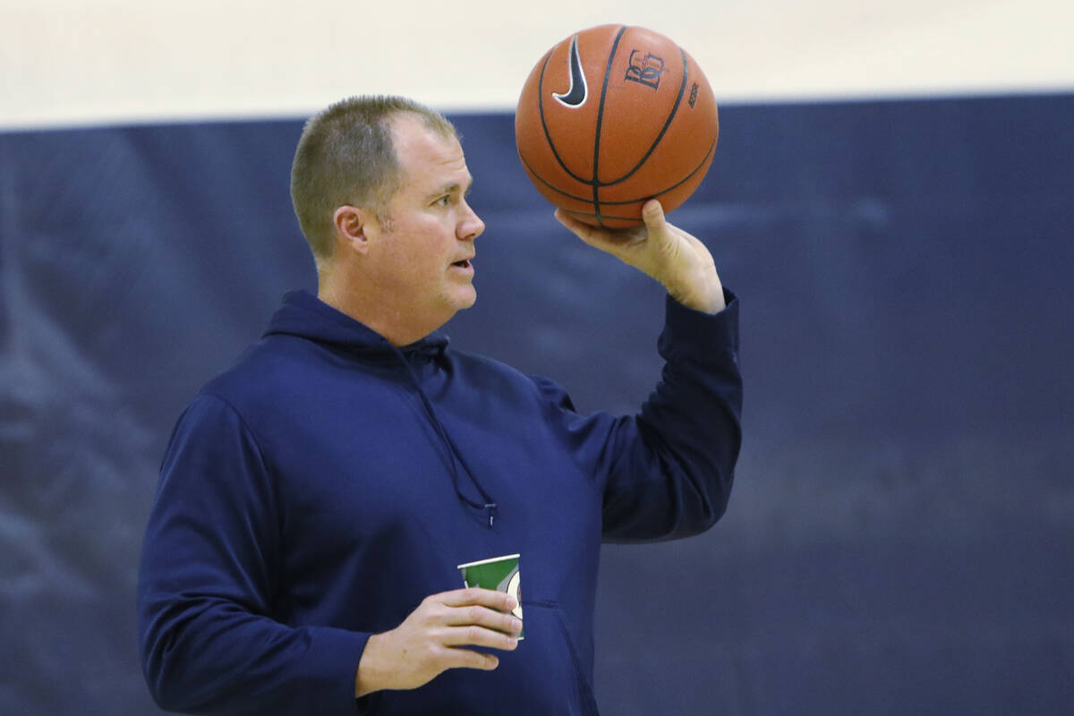 Bishop Gorman basketball head coach Grant Rice, right, holds a ball during a basketball practic ...