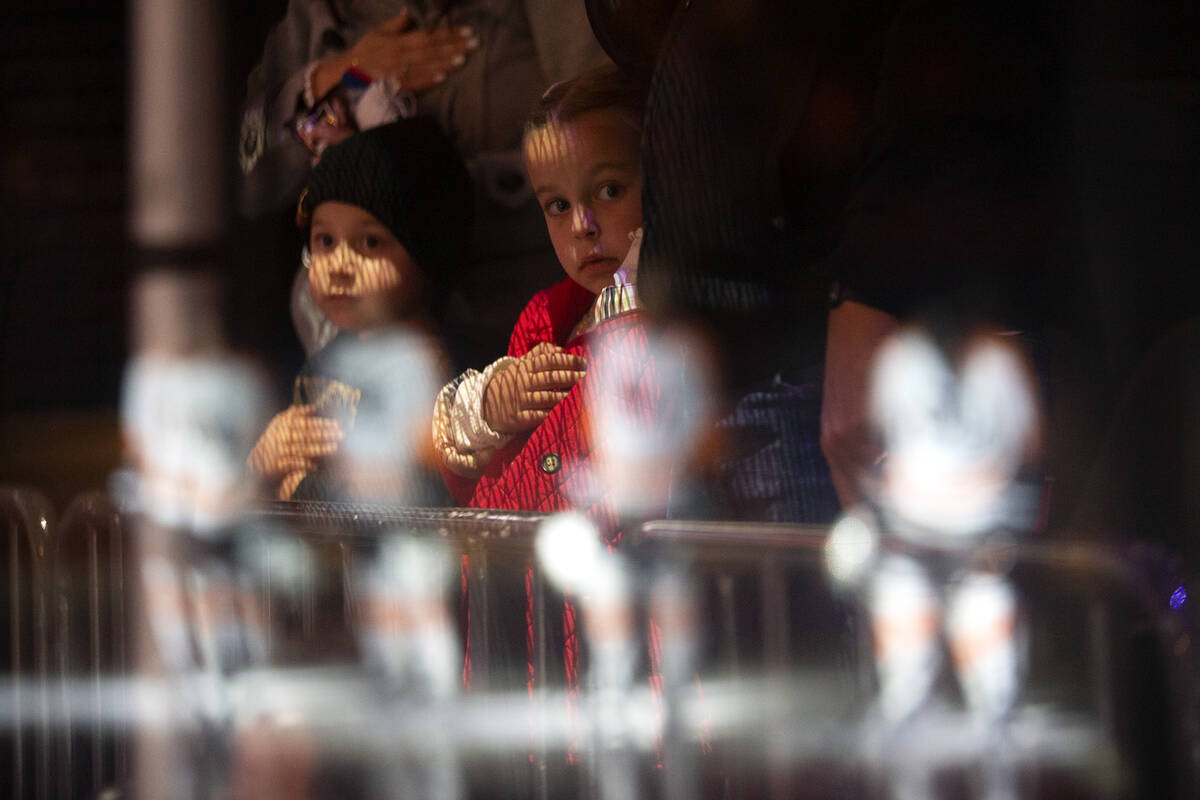 Young Golden Knights fans watch as the national anthem is sung and Flyers players are reflected ...