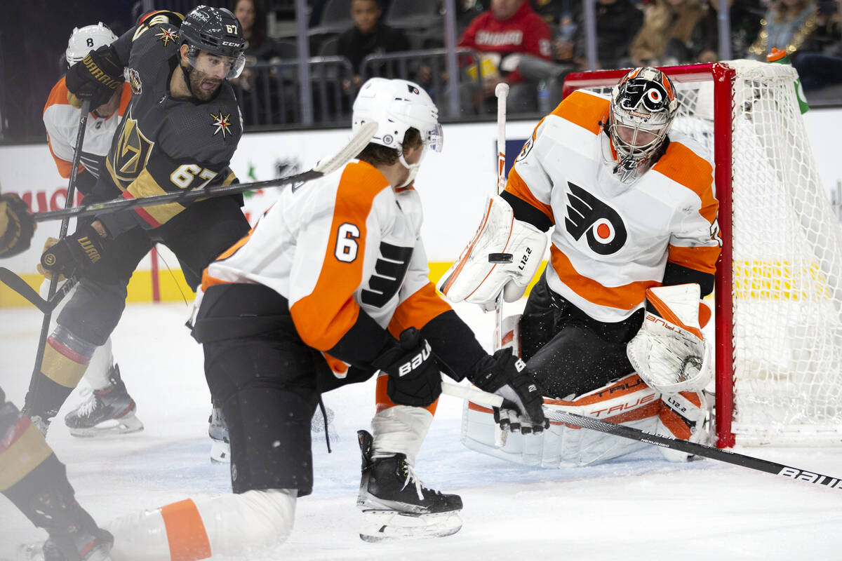 Flyers goaltender Carter Hart (79) saves a shot on goal by Golden Knights left wing Max Paciore ...