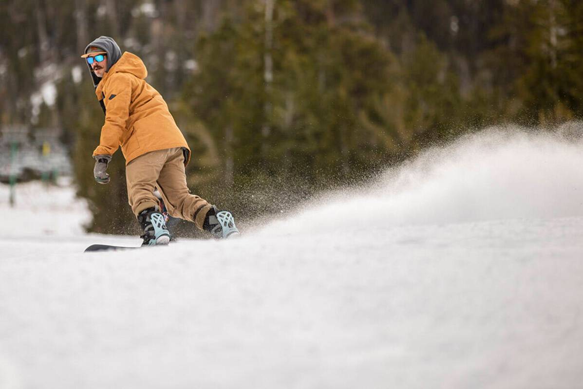 Snowboarder Ian Ryan of Las Vegas glides down a run near the lodge during opening day of skiing ...