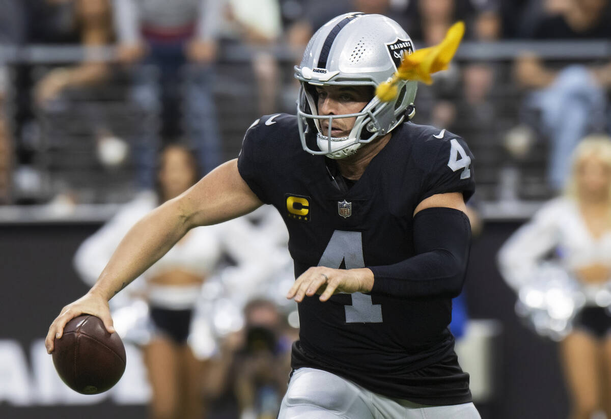 Raiders quarterback Derek Carr (4) scrambles as a penalty is thrown during an NFL football game ...