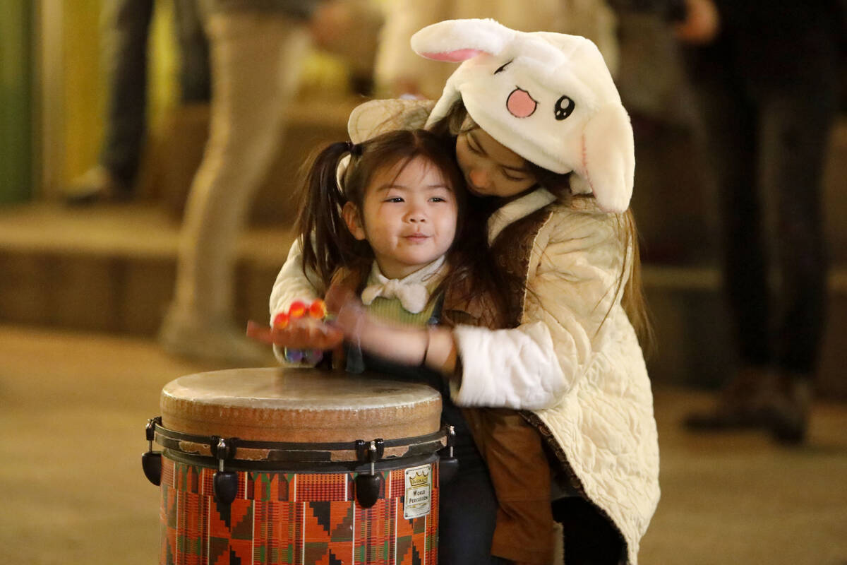 Adeline Montes, 10, of Las Vegas and her sister Olive Effendy, 3, play drum together, Saturday, ...