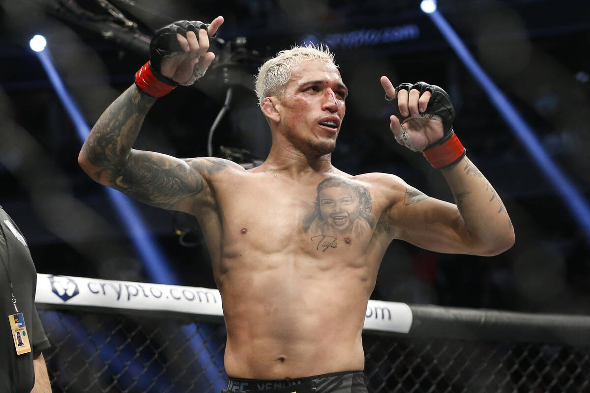 Charles Oliveira reacts after defeating Dustin Poirier by submission in a lightweight mixed mar ...
