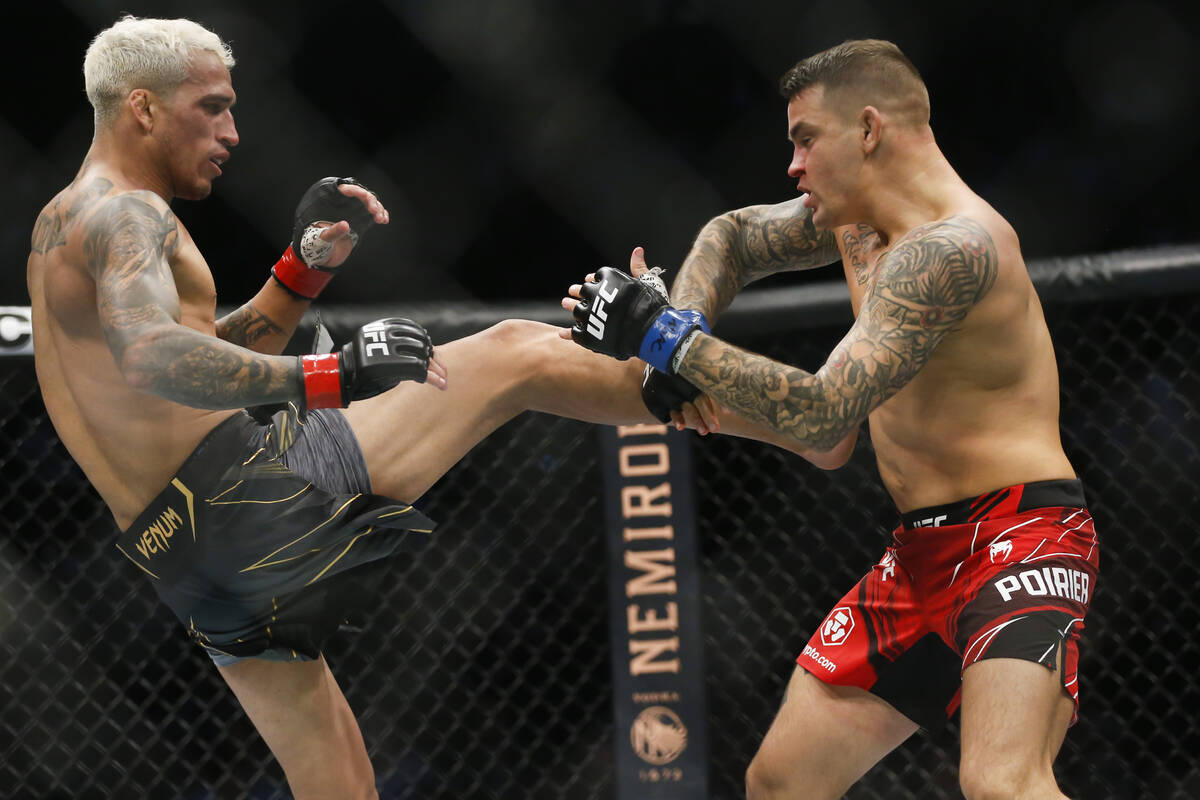 Charles Oliveira, left, tries to kick Dustin Poirier during a lightweight mixed martial arts ti ...