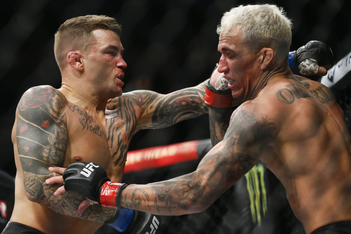 Dustin Poirier, left, fights Charles Oliveira during a lightweight mixed martial arts title bou ...