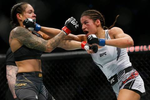 Julianna Pena, right, hits Amanda Nunes during a women's bantamweight mixed martial arts title ...