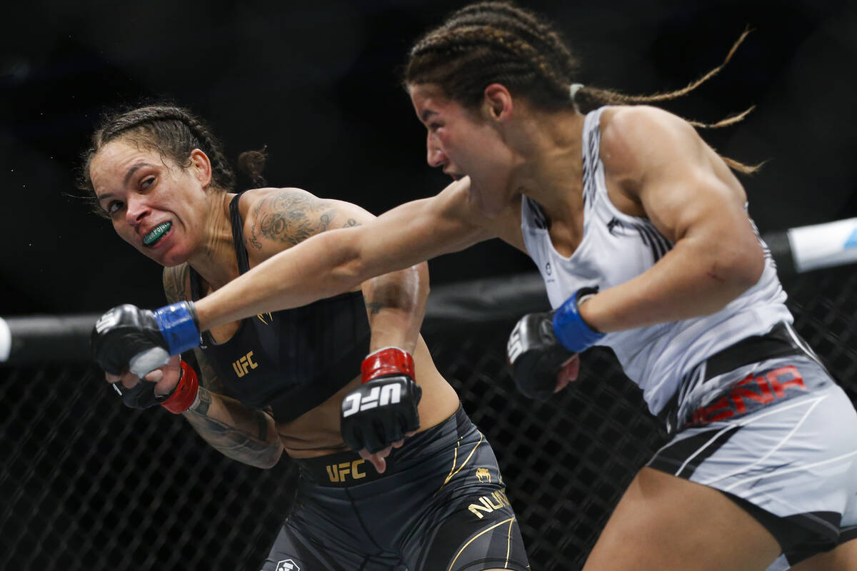 Julianna Pena, right, throws a right to Amanda Nunes during a women's bantamweight mixed martia ...