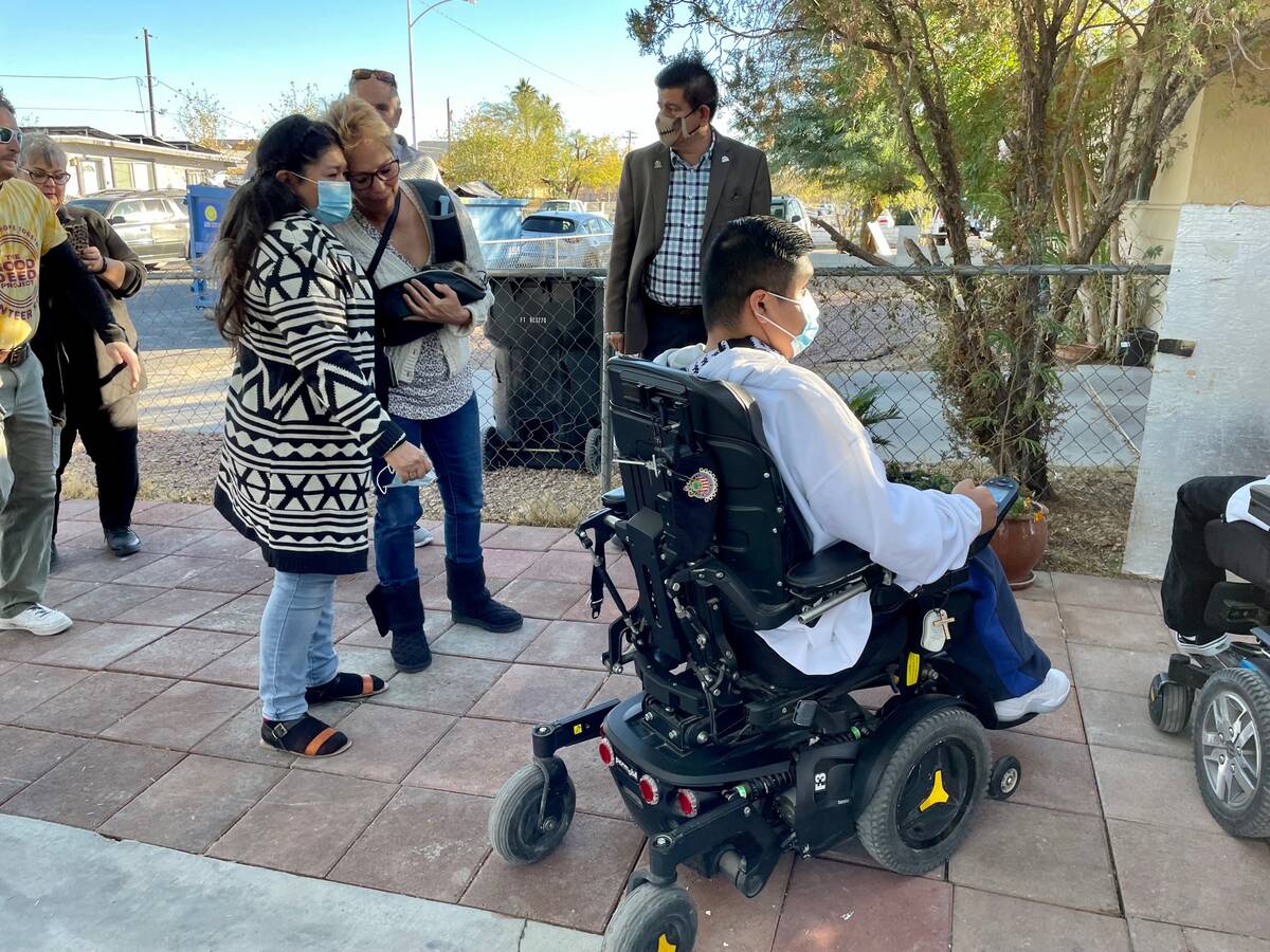 Maria Velazquez, left, embraces Ivy Unieski of the Nevada Wheelchair Foundation, as Brian Velaz ...