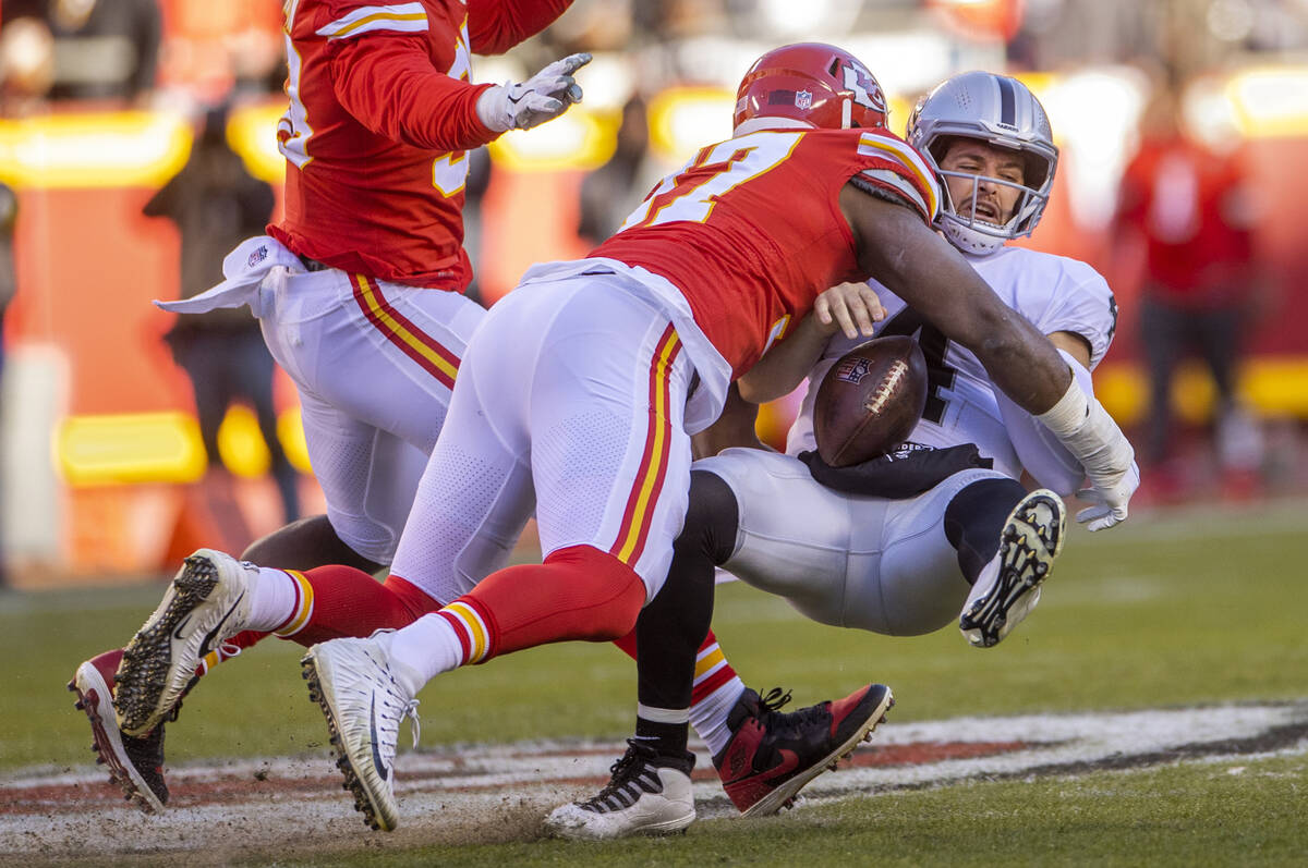 Raiders quarterback Derek Carr (4) is sacked and fumbles the ball after a big hit by Kansas Cit ...
