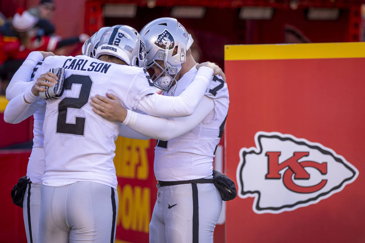 Raiders kicker Daniel Carlson (2) and wide receiver Zay Jones (7) pray with a teammate while ta ...