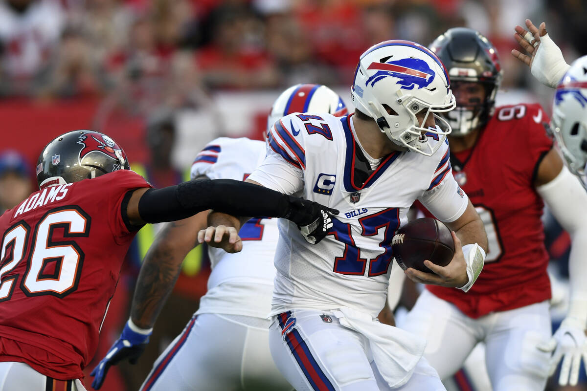 Tampa Bay Buccaneers safety Andrew Adams (26) grabs Buffalo Bills quarterback Josh Allen (17) b ...