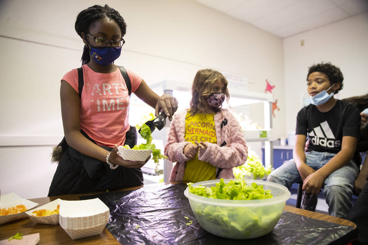 Kha'Laela Robinson, 10, from left, makes a salad as Ava Fountain, 7, and Aviyon Johnson, 9, wai ...