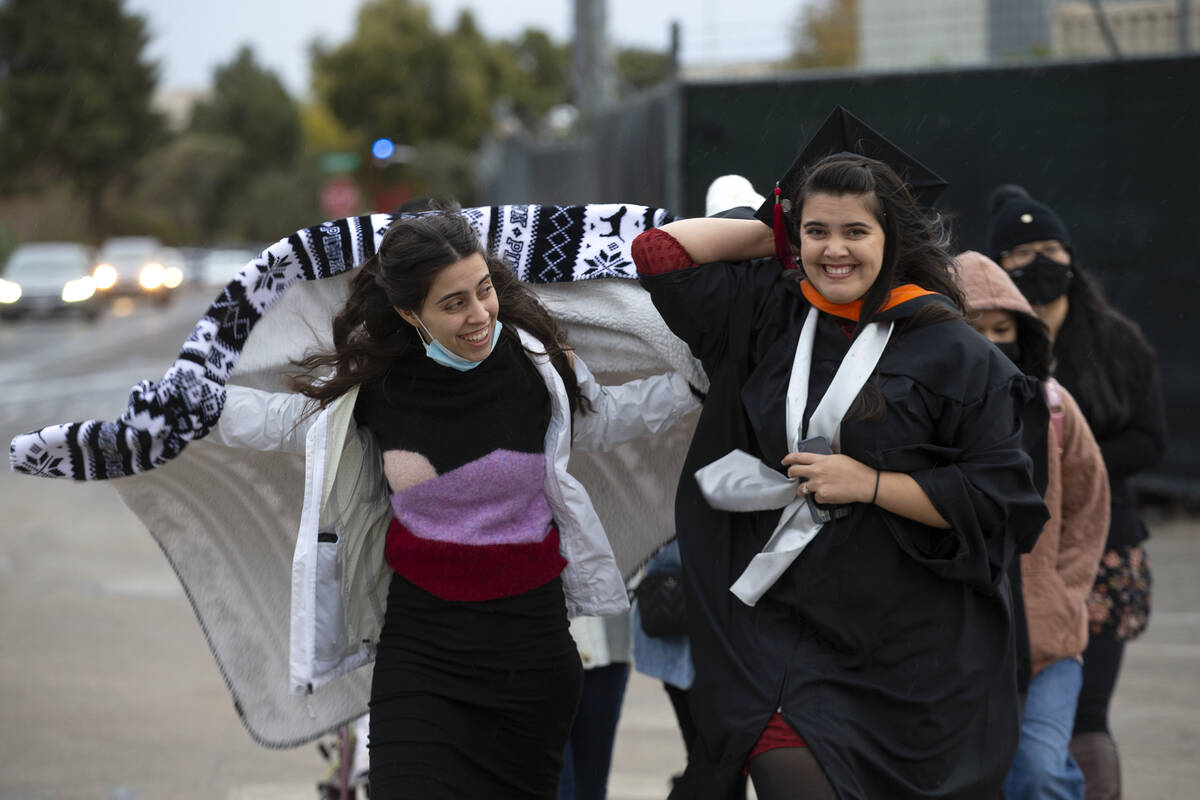 Sisters Kimberly Gonzalez, left, and Aimee Gonzalez, walk through wind and rain into AimeeÕ ...