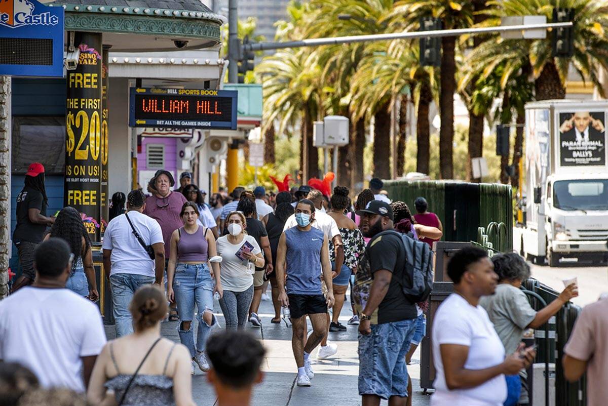 People walk along the Strip near The Venetian, most not wearing masks anymore on Friday, July 1 ...