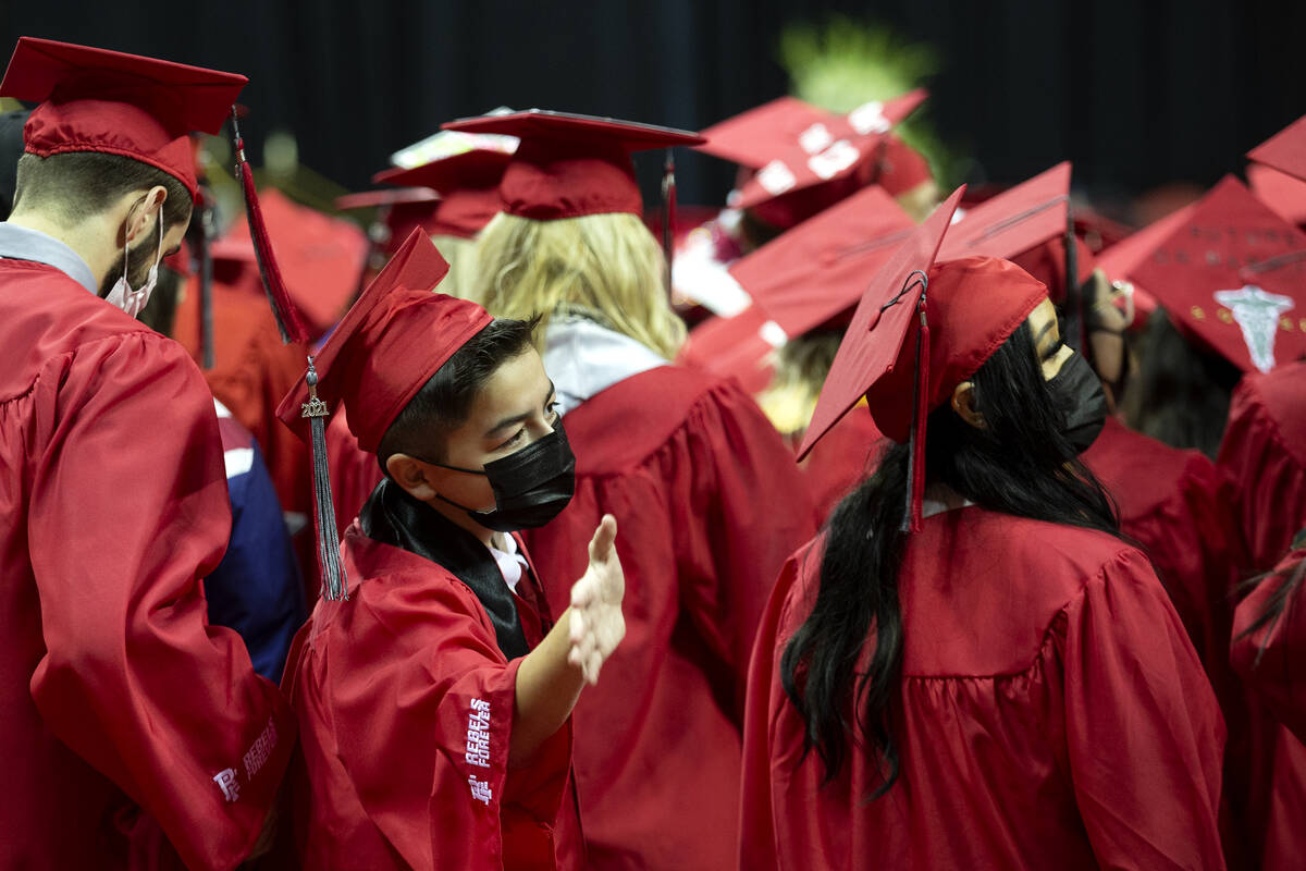 Jack Rico, a 15-year-old UNLV graduate in history, waves to family members in the audience duri ...