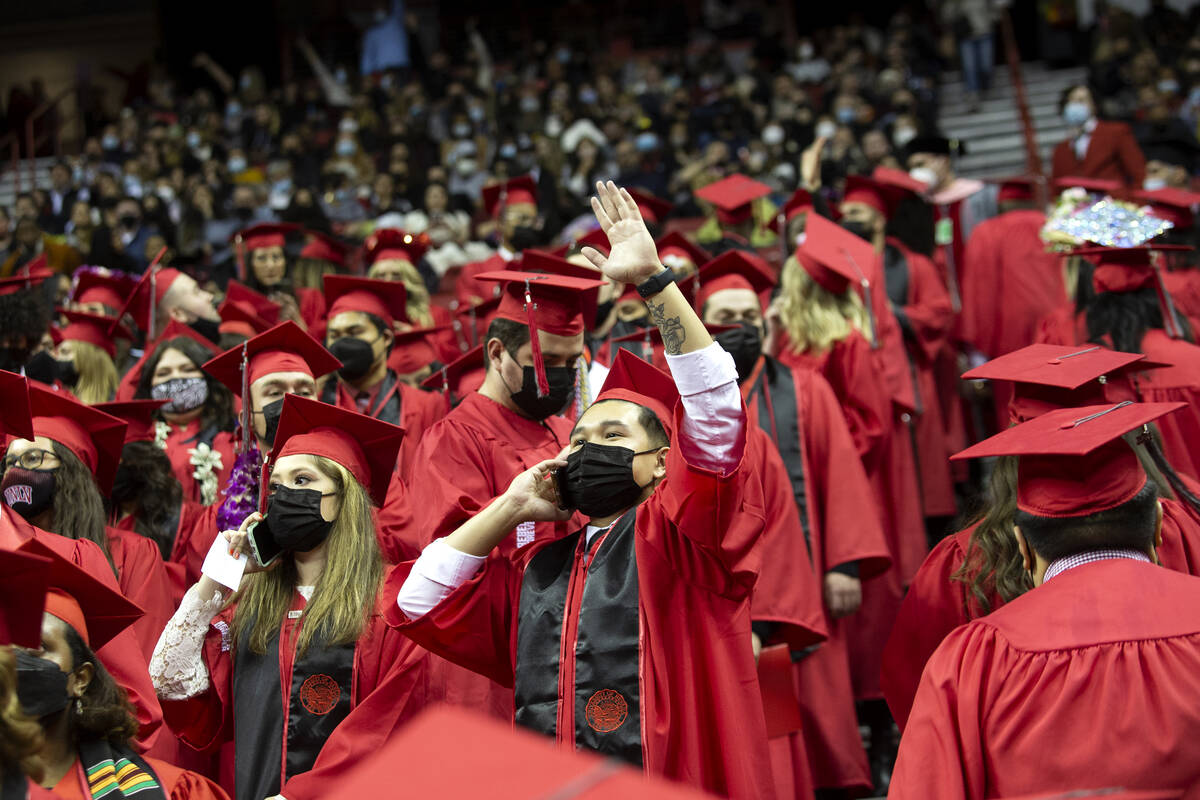UNLV biology graduate Ryan Tobias, center, waves to friends and family during his commencement ...