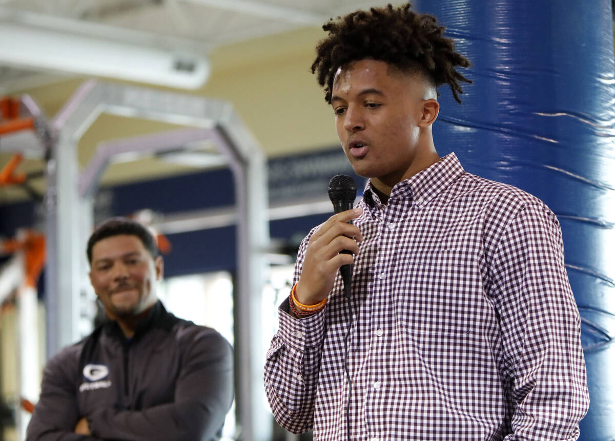 Bishop Gorman High School football player Benjamin Hudson, right, speaks before signing with St ...