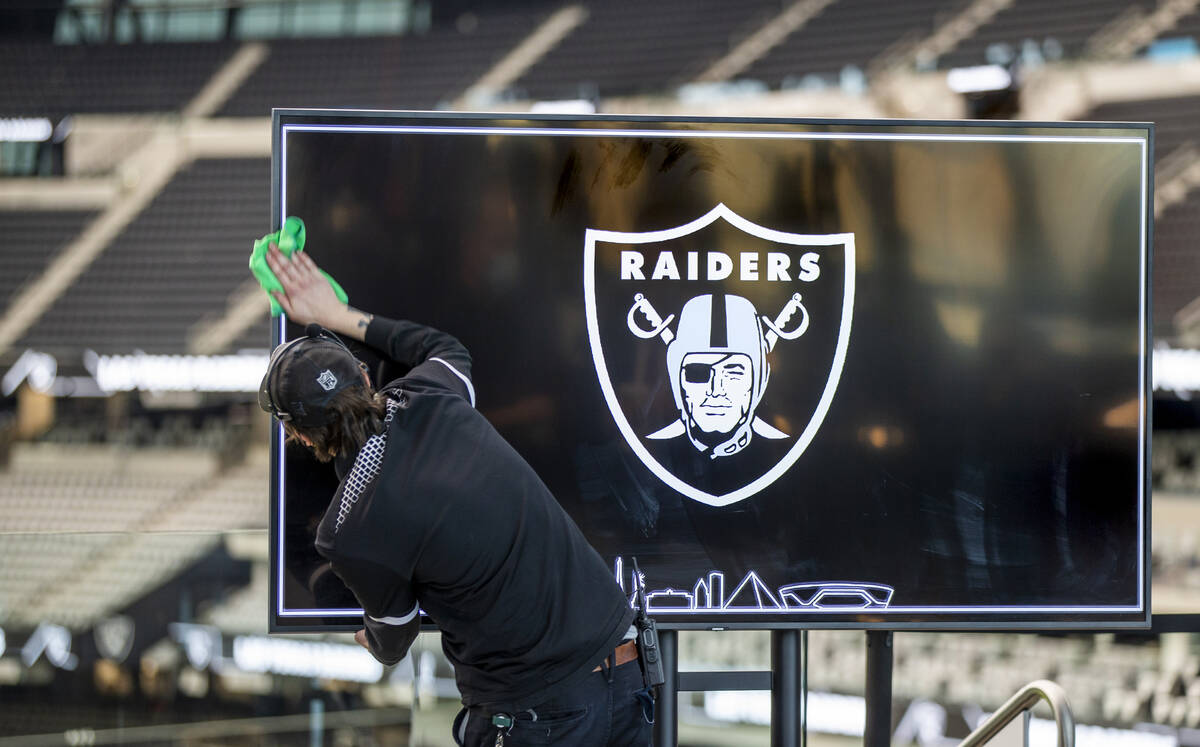 Video screens are cleaned before a press conference event announcing the NFL Super Bowl LVIII w ...