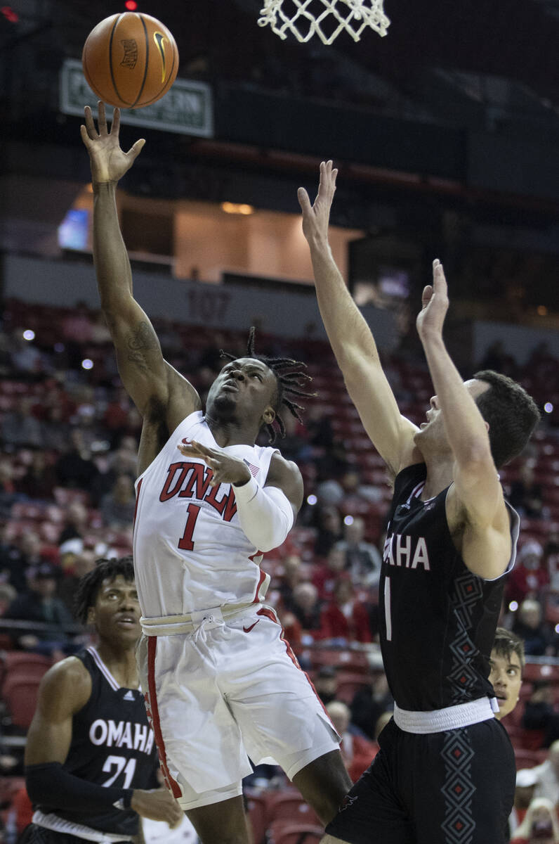 UNLV Rebels guard Michael Nuga (1) drives past Omaha Mavericks center Dylan Brougham (14) in th ...