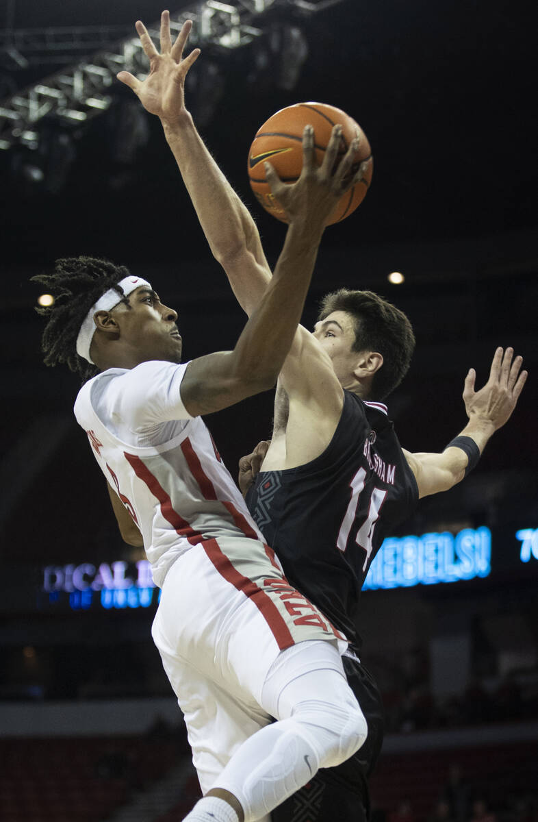 UNLV Rebels forward Donovan Williams (3) drives past Omaha Mavericks center Dylan Brougham (14) ...